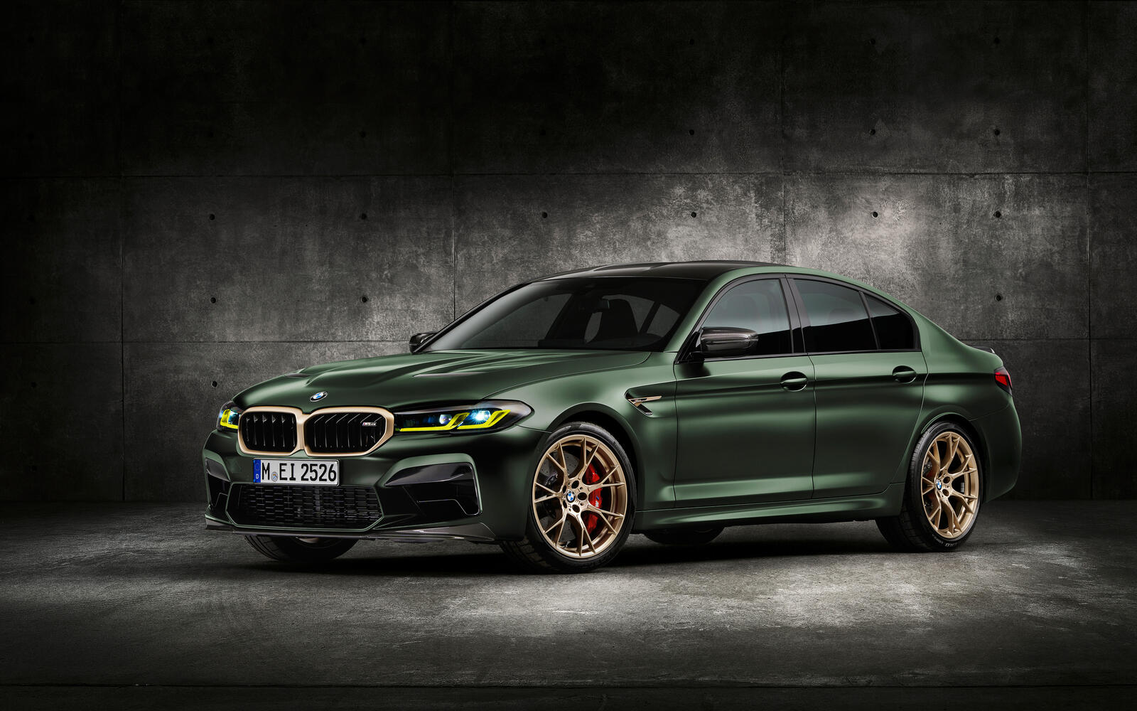 Free photo A green BMW M5 on gold rims.