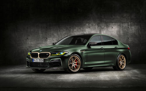 A green BMW M5 on gold rims.