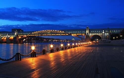 A bridge over a river in Moscow in the late evening