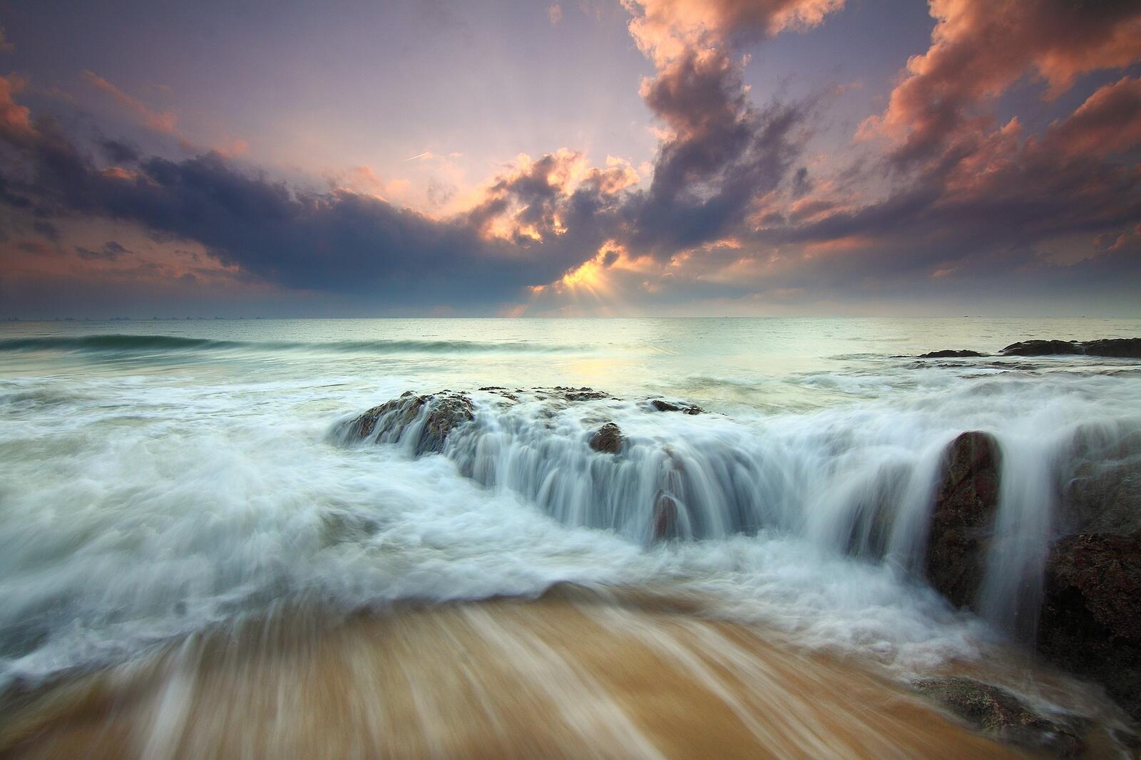 Бесплатное фото Небольшой водопад на берегу моря