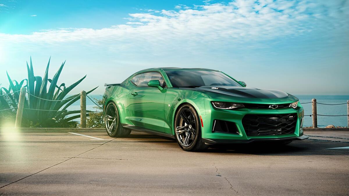 Green Chevrolet Camaro standing in front of the sea