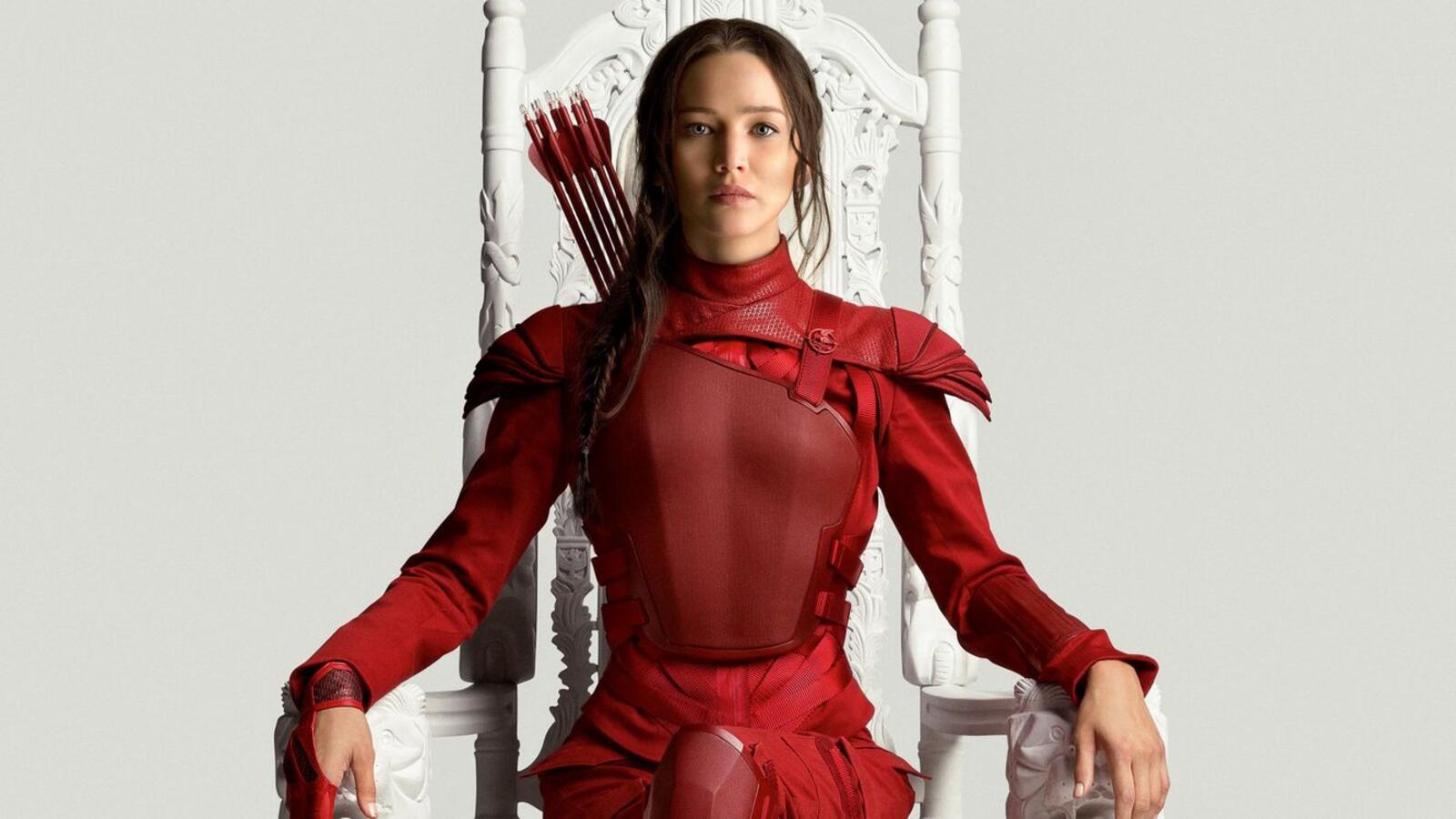 Бесплатное фото Дженифер Лоуренс сидит на троне в красном костюме