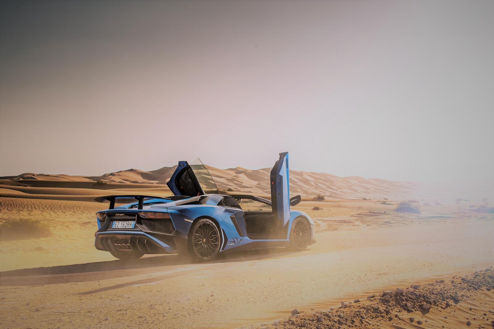 Free photo Lamborghini Aventador standing on the dust with the doors open