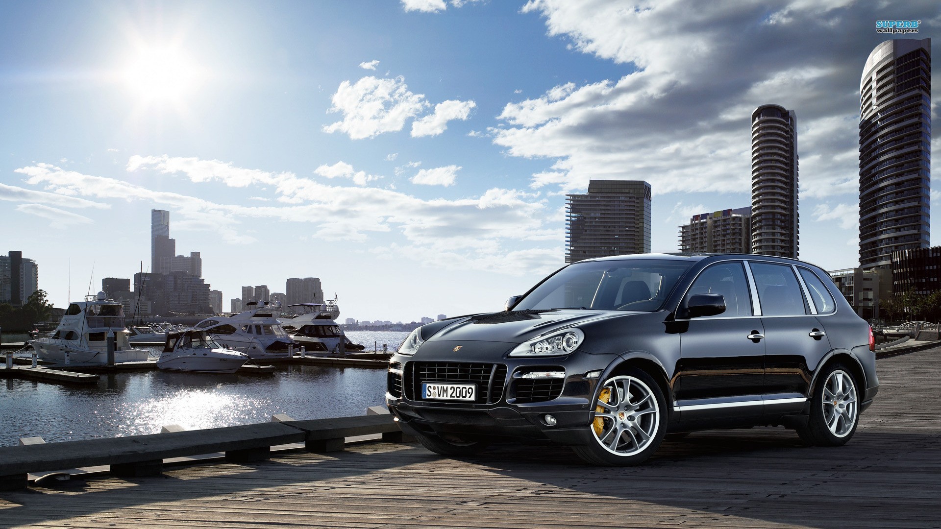 Free photo An old Porsche Cayenne with the city as a backdrop.