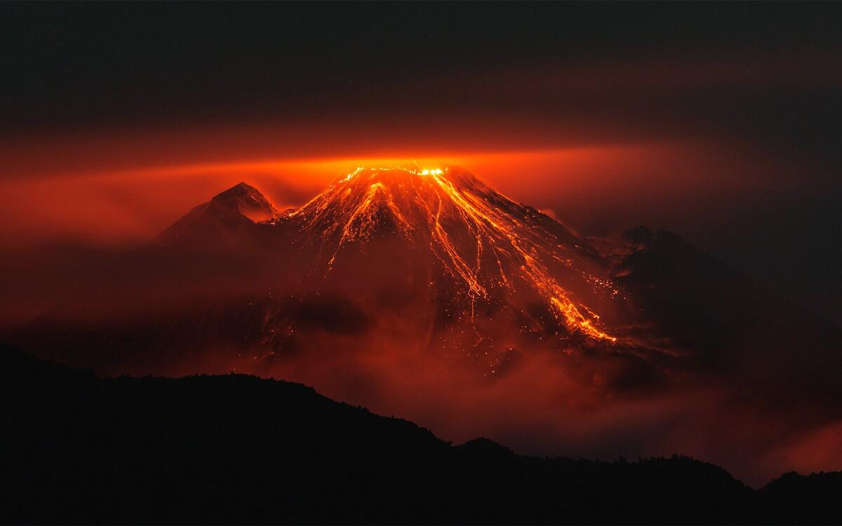 An erupting volcano in the night