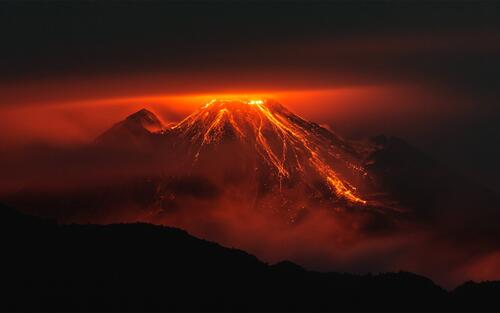 An erupting volcano in the night