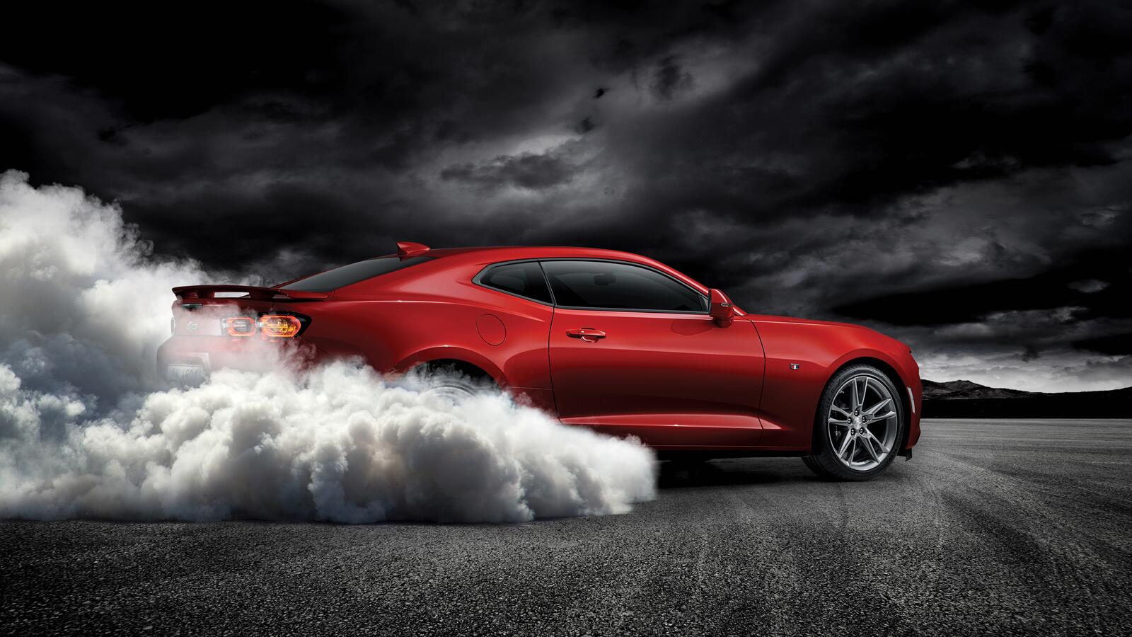 Free photo Drifting in place on a red chevrolet camaro ss.