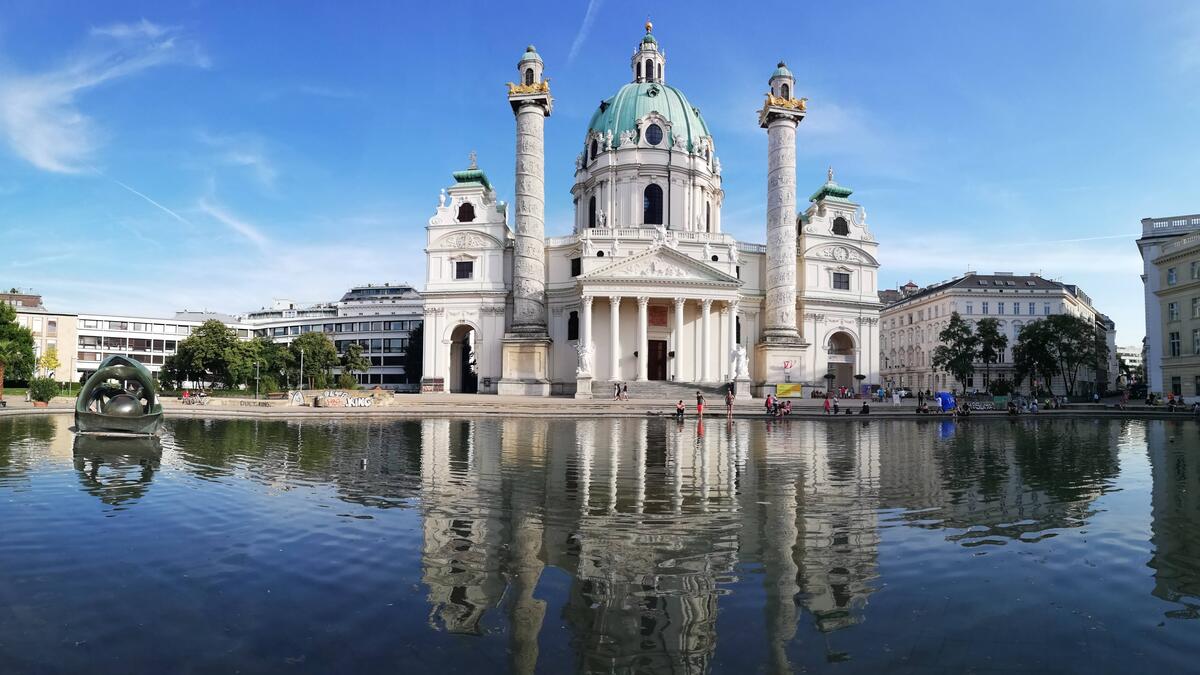 A white cathedral in Austria reflected in a body of water