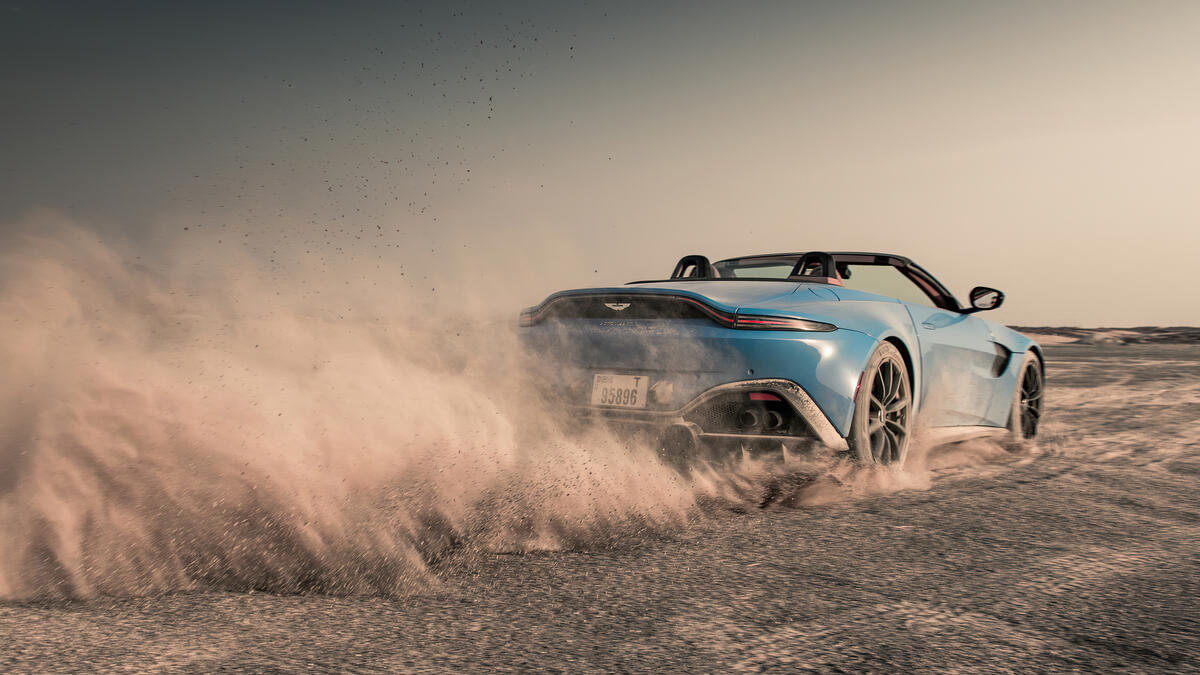 On a blue Aston Martin through the dust