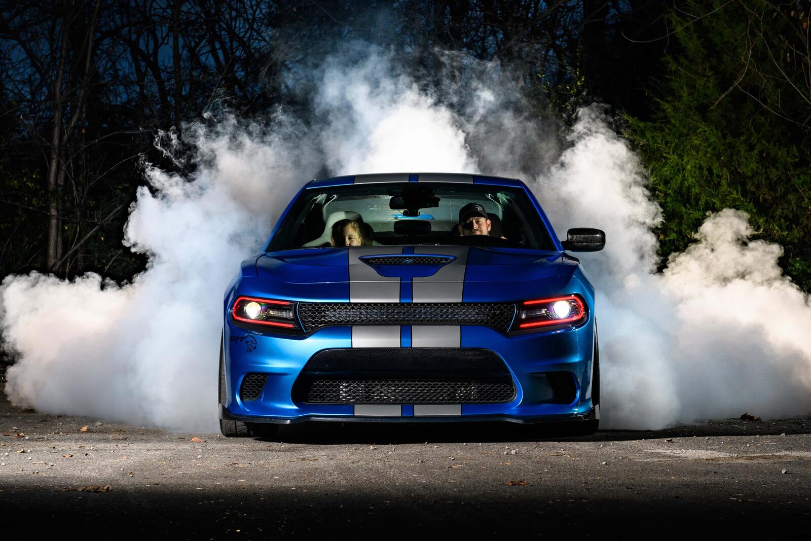 Free photo Blue Dodge with silver stripes drifting in place.