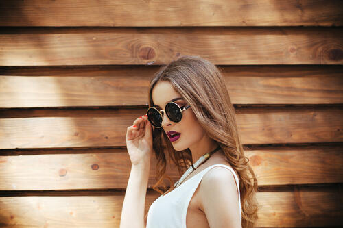 Молодая девушка в круглых солнцезащитных очках