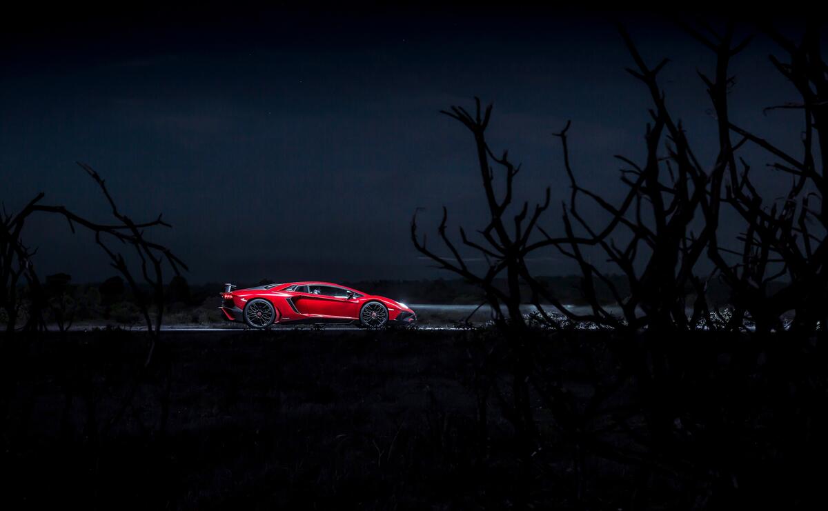 A red Lamborghini Aventador in the night.