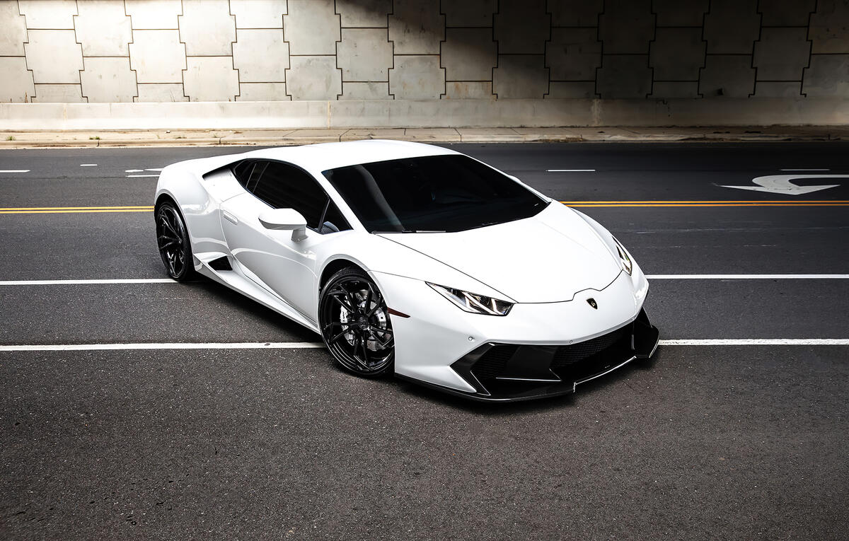 Белая Lamborghini Huracan стоит поперек дорожных полос