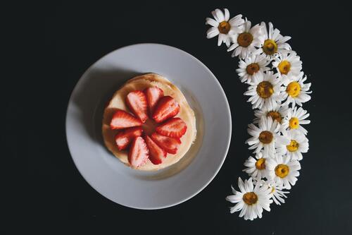 Pancakes with strawberries and camomile flowers