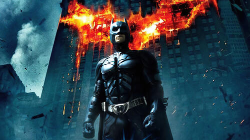 Batman in front of a burning building