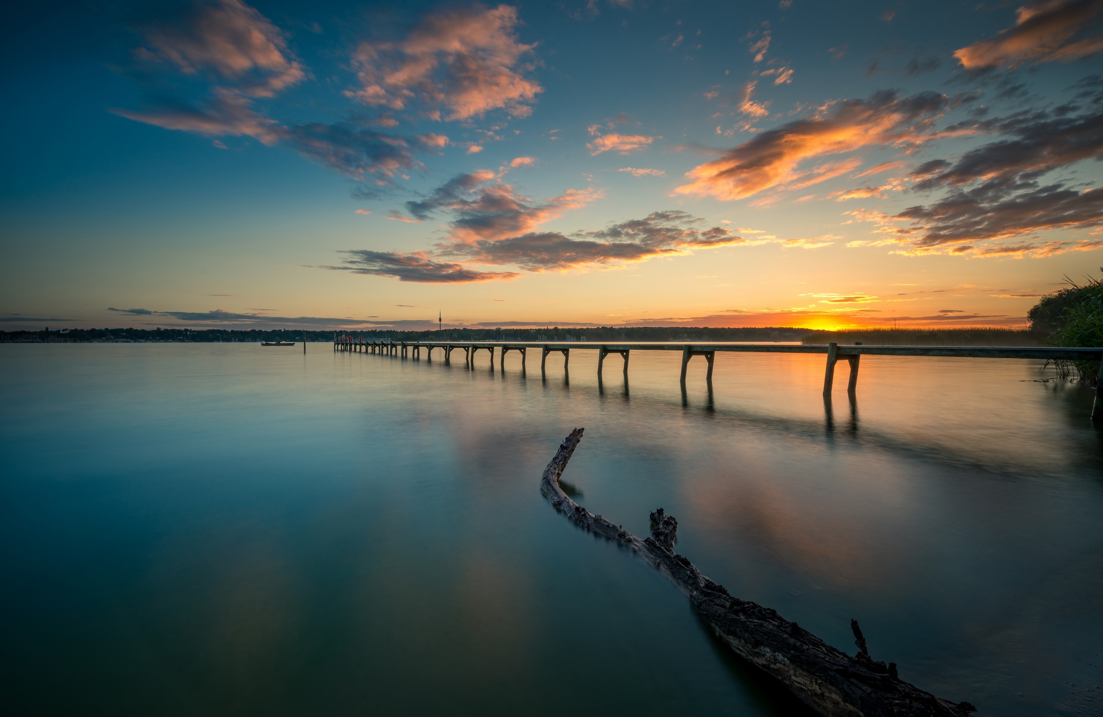 免费照片夕阳下的河上长长的人行桥