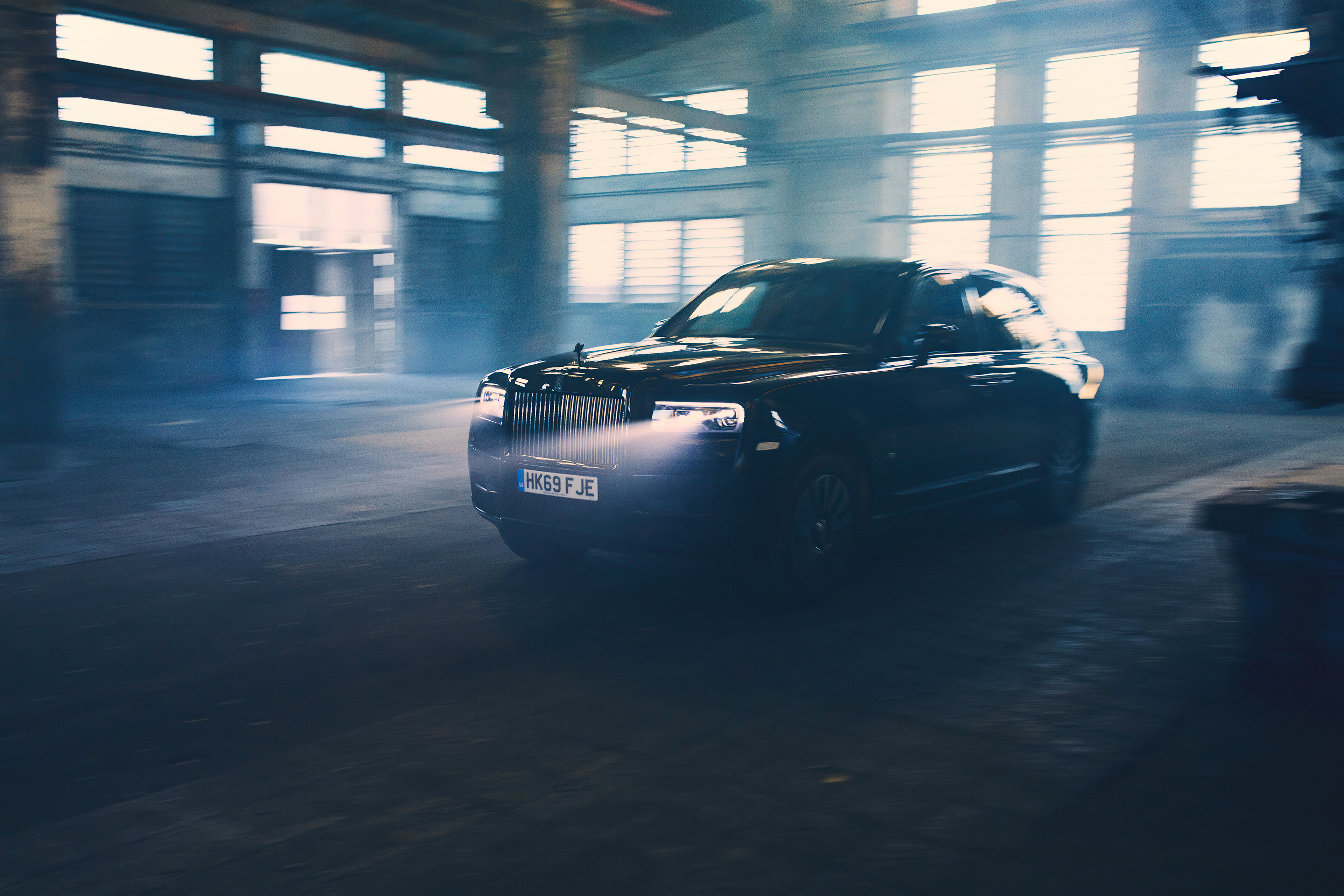 Black Rolls Royce Cullinan in a dusty garage
