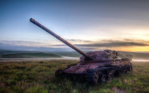 Заброшенный танк леопард в поле на закате