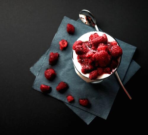A glass of cold ice cream and raspberries