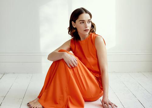 Emilia Clarke in an orange dress