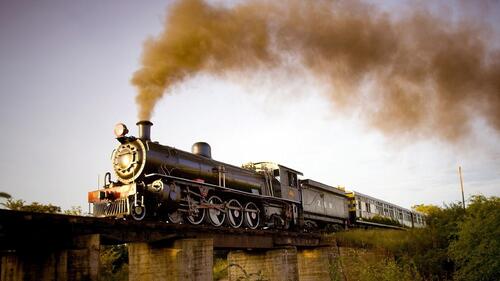A steam locomotive on a stone bridge