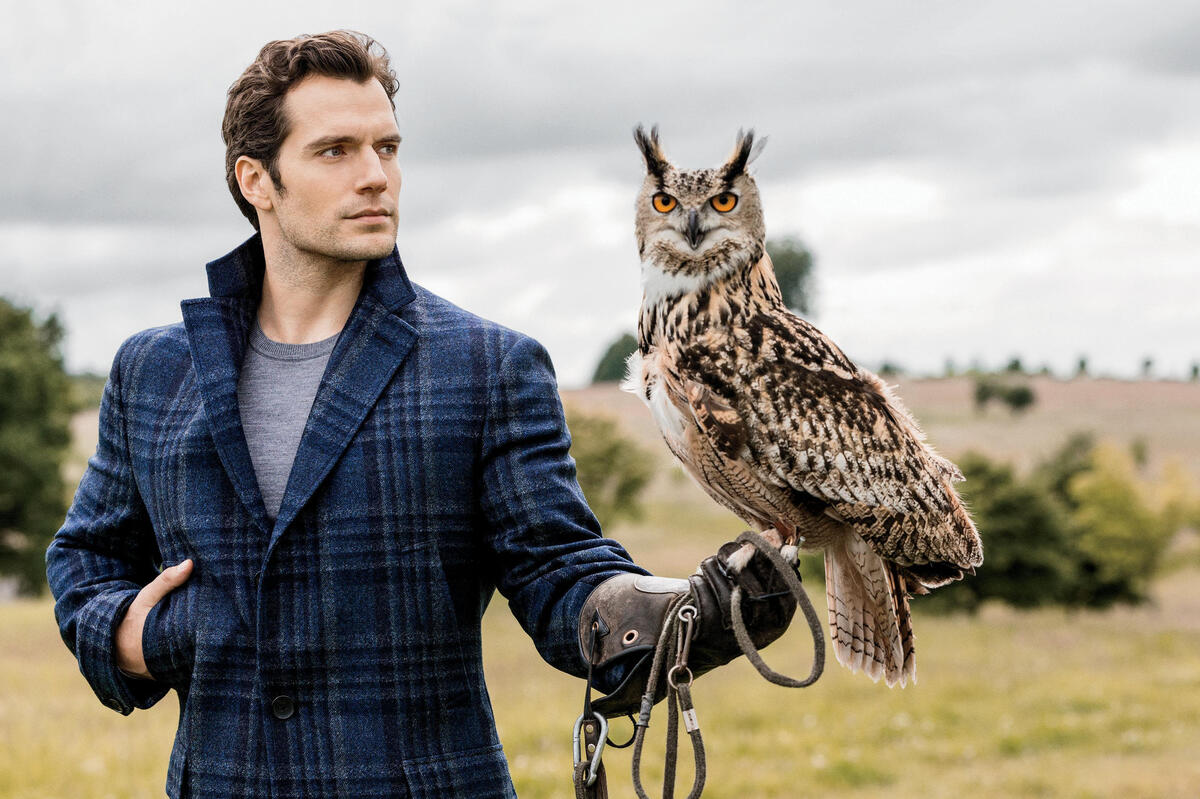 Henry Cavill with an owl on his arm.