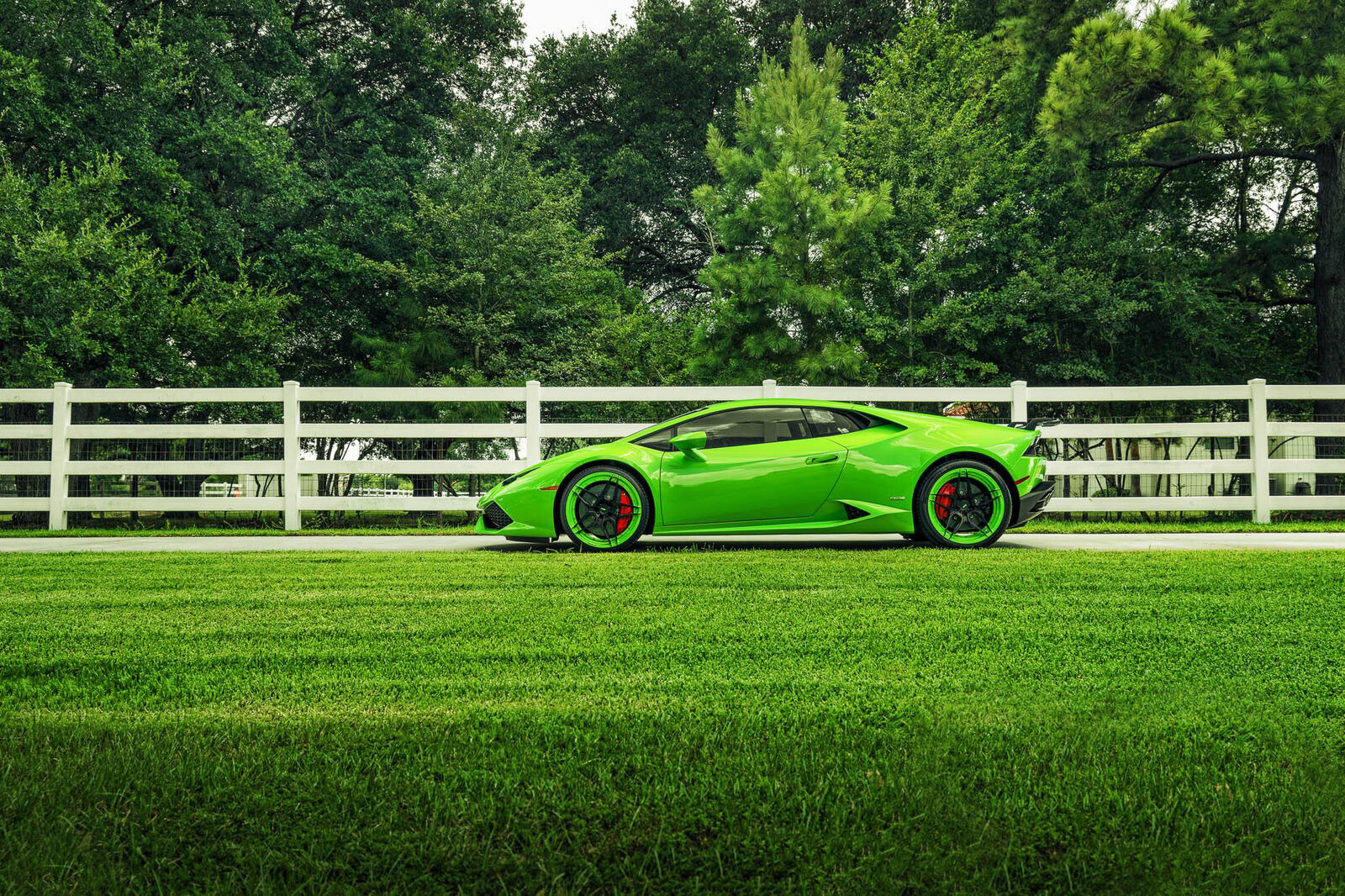 Бесплатное фото Lamborghini Huracan зеленого цвета на фоне зеленого поля