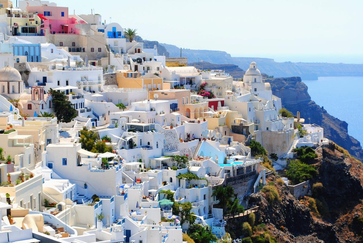 White houses stand on a cliff by the sea